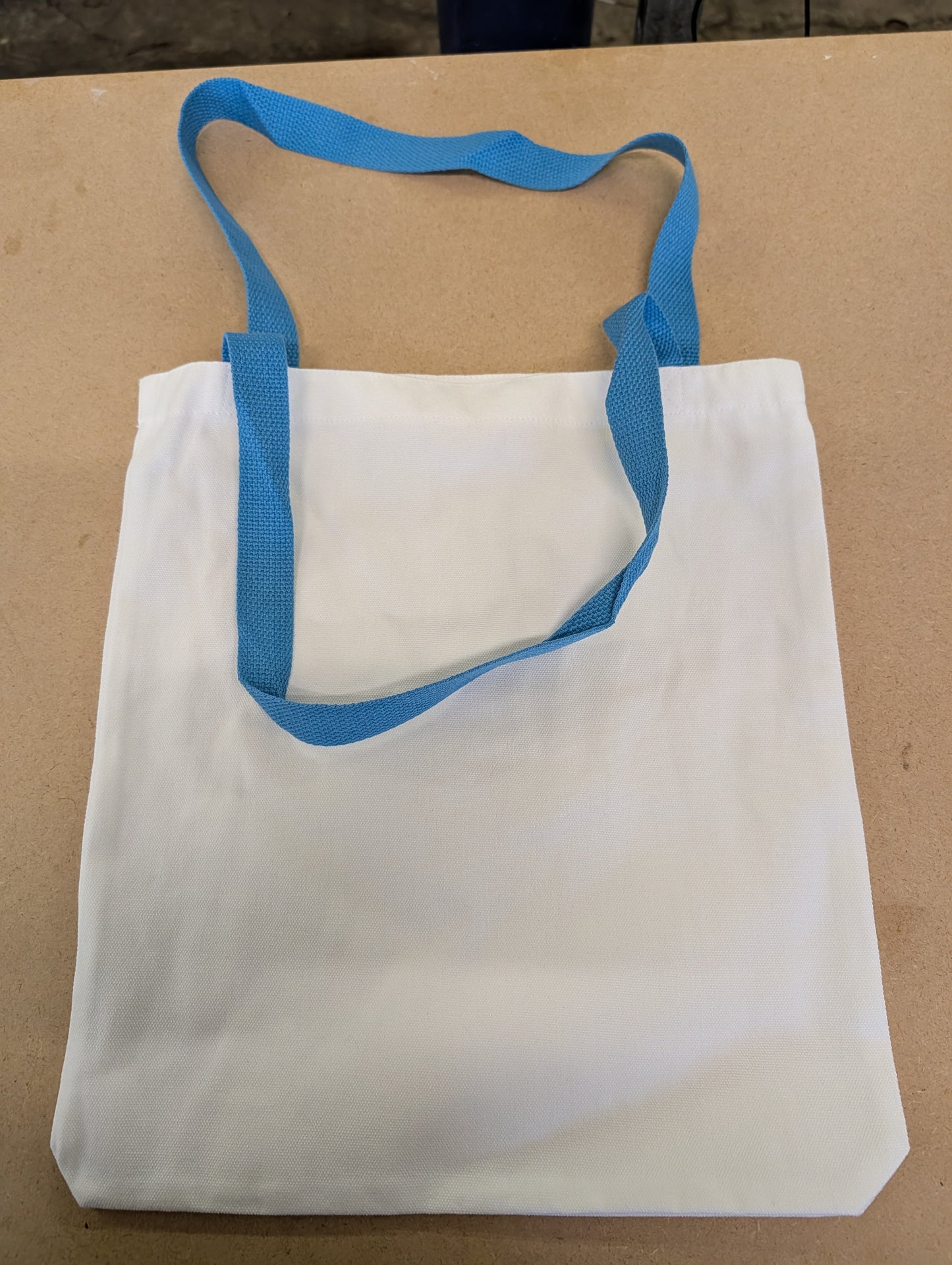 white canvas style tote bag with light blue Handles